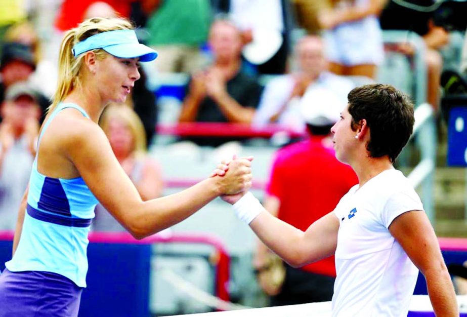 Maria Sharapova (L) of Russia shakes hands after being defeated by Carla Suarez Navarro of Spain during the Rogers Cup at Uniprix Stadium in Montreal, Canada on Thursday.