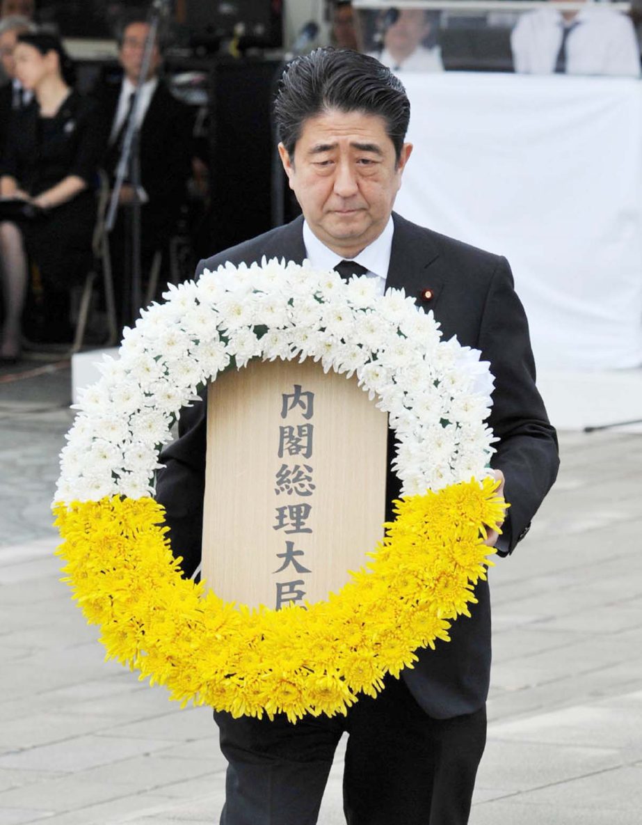 Japanese Prime Minister Shinzo Abe offers a wreath of flowers during a memorial service at Nagasaki Peace Park on Saturday.