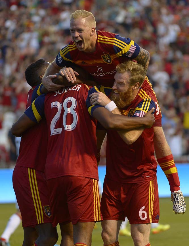 Real Salt Lake midfielder Luke Mulholland (top) forward Olmes Garcia (left) and defender Nat Borchers (6) mob defender Chris Schuler (28) after one of his two goals during the first half against DC United in an MLS soccer game in Sandy, Utah on Saturday.