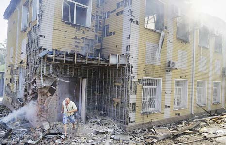 A man runs out of a building destroyed by shelling in Donetsk.