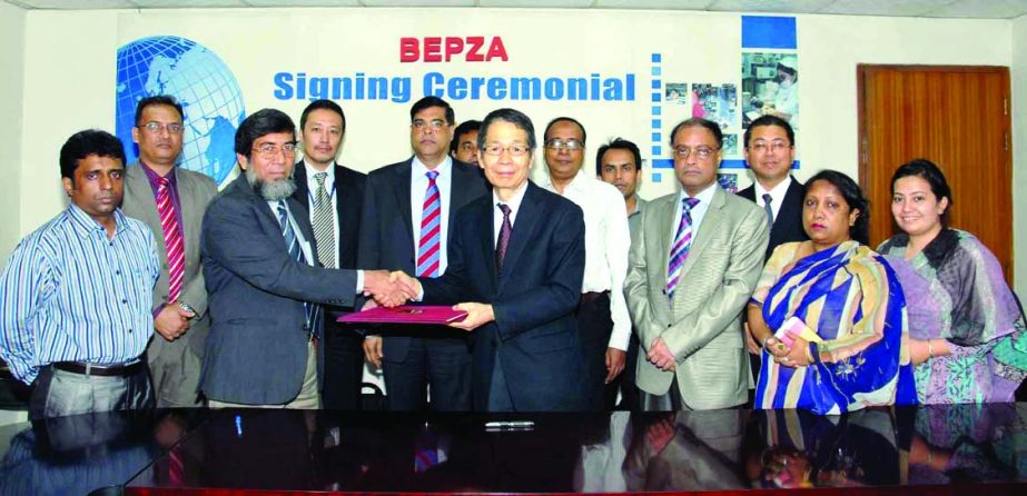 Sayed Nurul Islam, Member (Investment Promotion) of BEPZA and Fujikawa Masaru, Managing Director of JB Networks Co. Ltd sign a deal at BEPZA complex in the city to set up a leather products plant in Comilla EPZ on Monday.