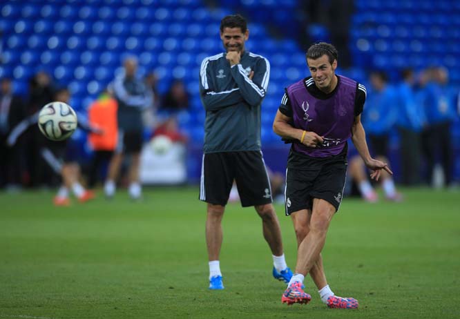 Real Madrid's Gareth Bale, practices free kicks, watched by coach Fernando Hierro during a training session at Cardiff City Stadium in Wales on Monday.