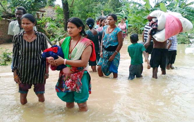 Nepalese villagers carry their belongings while wading through a flooded street to move to safer ground, at Bardia, in western Nepal.