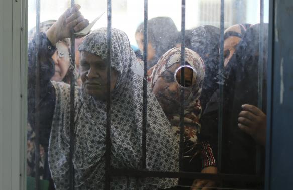 Palestinians wait to receive food supplies from a United Nations food distribution center in Khan Younis in the southern Gaza Strip August 19, 2014. Credit: REUTERSIbraheem Abu Mustafa