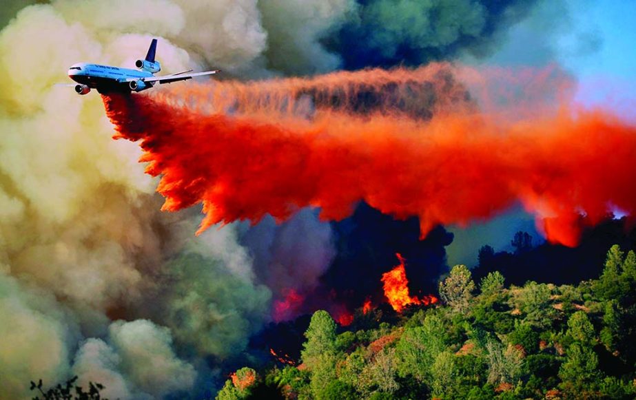 An air tanker drops fire retardent on a fire which was burning on a ridge northeast of Oakhurst, Calif.