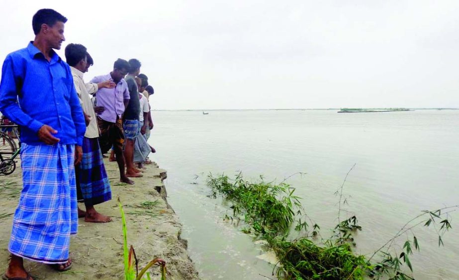 Jamuna River embankment built by the locals at Tartapara point in Jamalpur has been washed away due to onrush flood waters. Photo shows Panick-stricken people watching the damaged area.