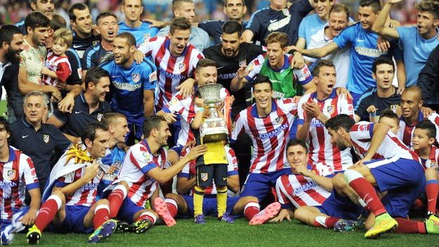 Players of Atletico Madrid celebrate with the trophy.