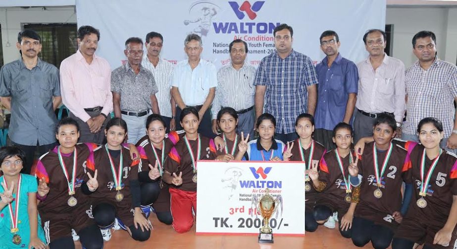 Members of Naogaon district team the third place achiever of the Walton Air Conditioner National (U-19) Youth Female Handball Tournament with the officials of Bangladesh Handball Federation and the guests pose for a photograph at the Shaheed (Captain) M M