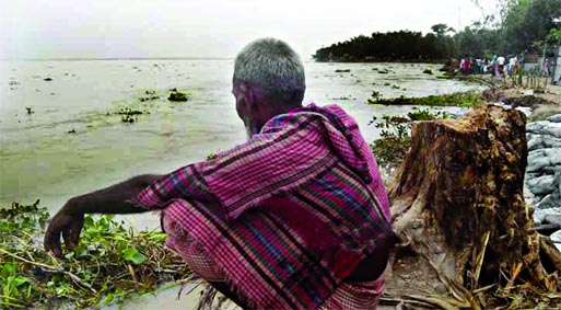 WITNESS TO DESTINY: An old man keeps his eye on the Teesta erosion that devoured some villages rendering many families remained homeless. This photo was taken from Gangachara upazila in Rangpur on Sunday.