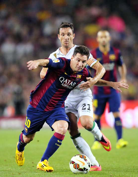 FC Barcelona's Lionel Messi from Argentina (left) duels for the ball against Elche's Edu Albacar during a Spanish La Liga soccer match at the Camp Nou stadium in Barcelona, Spain on Sunday.