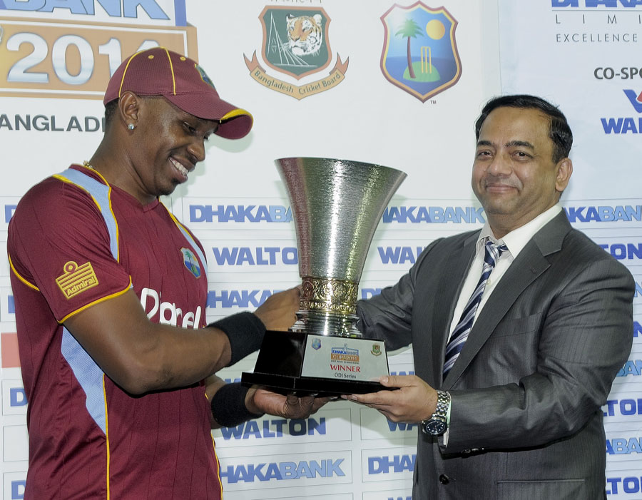 A beaming Dwayne Bravo accepts the series trophy after the 3rd ODI between West Indies and Bangladesh at Basseterre, St Kitts on Monday.