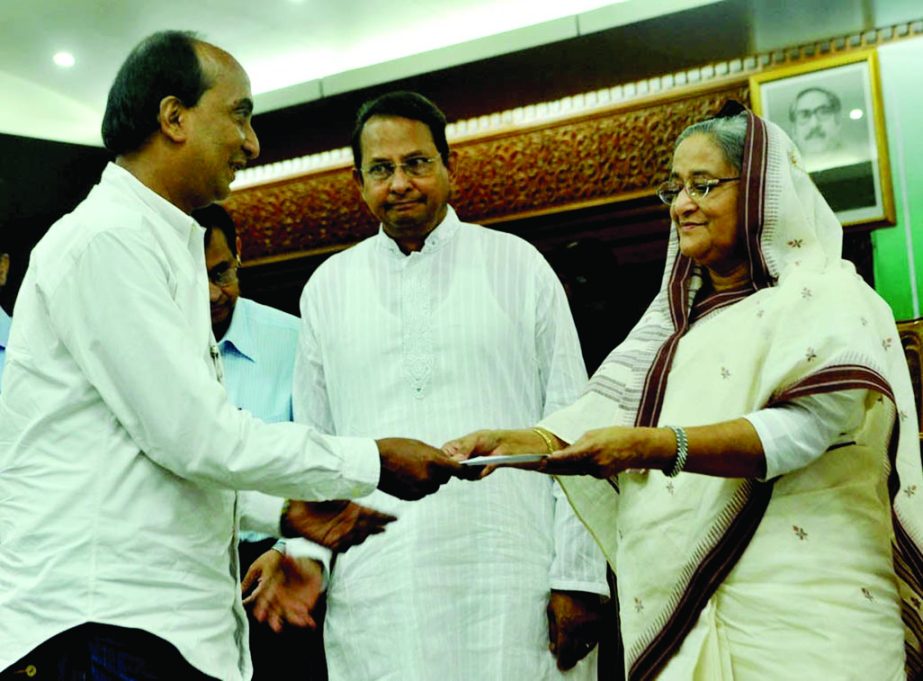 Prime Minister Sheikh Hasina handing over cheque of financial assistance among the sick, insolvent, injured journalists and family members of journalists who died at her office on Wednesday. BSS photo