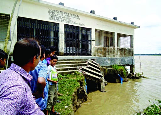 Char Baheratala Primary School may soon become history of past as erosion in Padma and Arial Kha river has already devoured a portion of the building. This photo was taken from Shibchar area on Wednesday.
