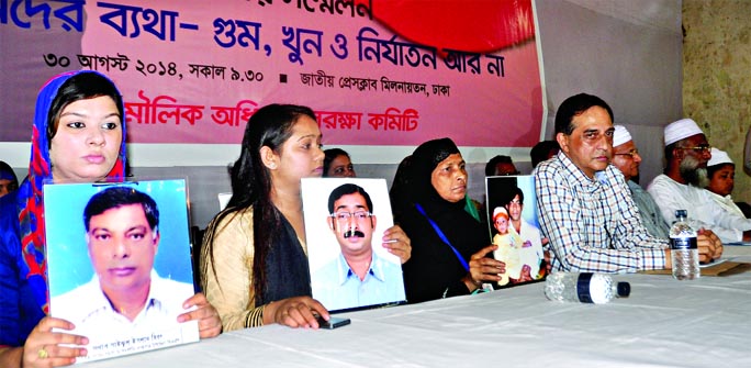 Members of the victims families of enforced disappearance showing the photos of their dear and near ones at the conference marking the International Enforced Disappearances Protection Day at Jatiya Press Club on Saturday.