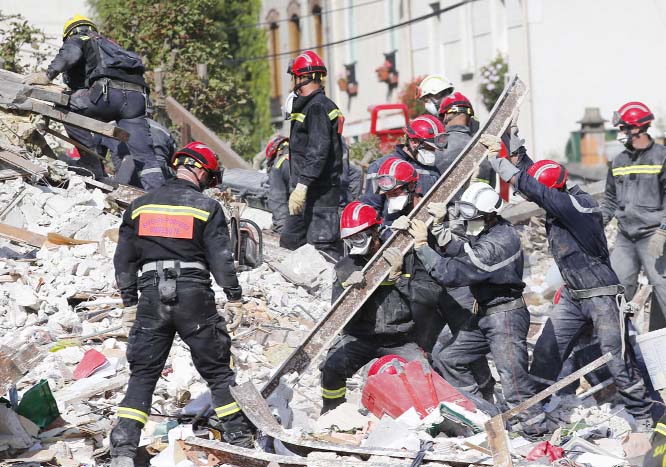 French firemen search in the rubble of a building after an explosion collapsed it, in Rosny-sous-Bois, outside Paris on Sunday