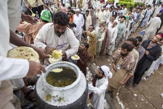 Anti-government protesters queue up to receive breakfast during the Revolution March in Islamabad on Tuesday.