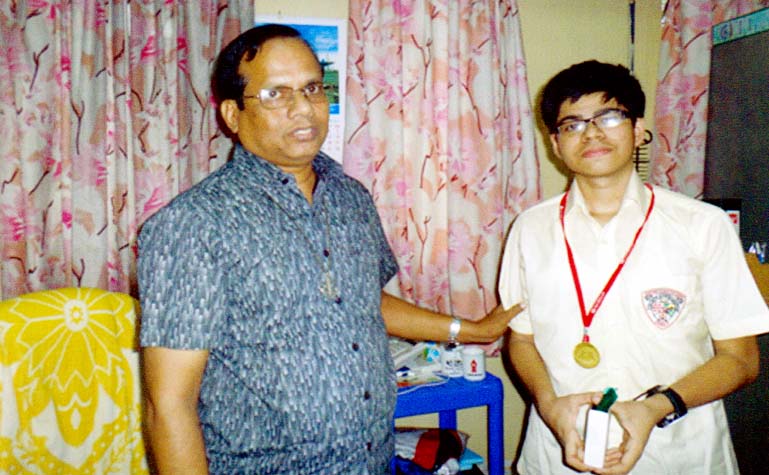 Principal of the city's Saint Joshef School Brother Rabi Purification pose for photograph with Ehsanul Haque Ayan who got gold medal in International Assessment for School Competition from the University of New South Wales, Australia recently.