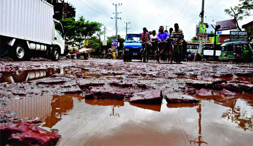 The city's busy road is in appalling situation as potholes and cracks developed due to stagnant rain waters causing serious sufferings to commuters and locals. This photo was taken from Jatrabari area on Tuesday.
