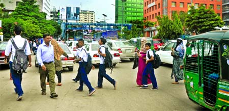 OVER BRIDGE IGNORED: In spite of several accidents in recent past and an over bridge only a few yards away, students of the city's Wills Little Flower School and their moms are seen crossing the busy road to attend classes on time taking risk of their li