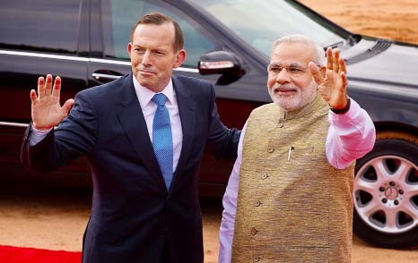 Australian Prime Minister Tony Abbott and his Indian counterpart Narendra Modi wave to photographers in New Delhi.