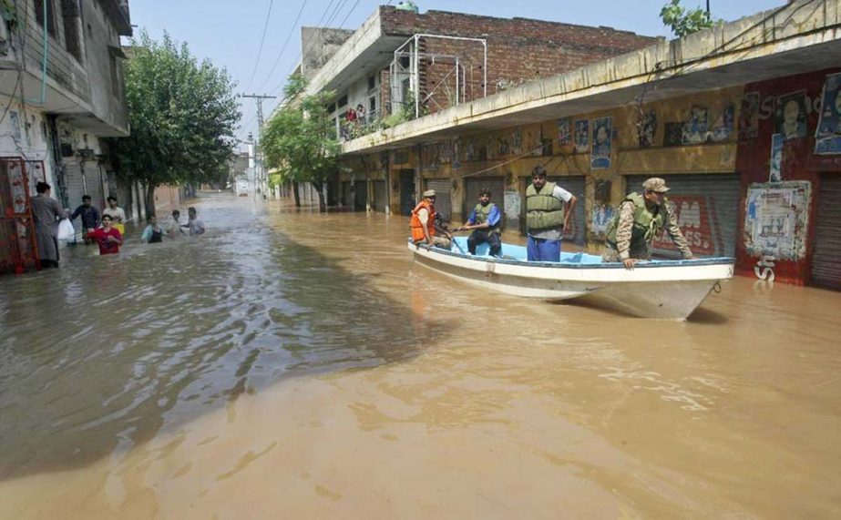 A Pakistani army soldier and volunteers use a boat in floodwater to rescue people after heavy monsoon rains in Wazirabad, some 100 kilometers (65 miles) north of Lahore, Pakistan on Sunday.