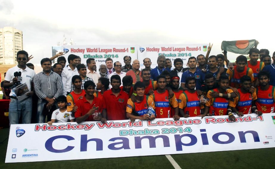 Members of Bangladesh team, the champions of the FIH World Hockey League Round-1 with guests and officials of Bangladesh Hockey Federation pose for a photo session at the Moulana Bhashani National Hockey Stadium on Sunday.
