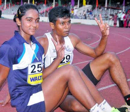 Mesbah Ahmed (right) and Shirin Akhter of Bangladesh Navy show victory sign after became fastest man and woman of the 12th National Summer Athletics Championship at the Bangabandhu National Stadium on Monday.