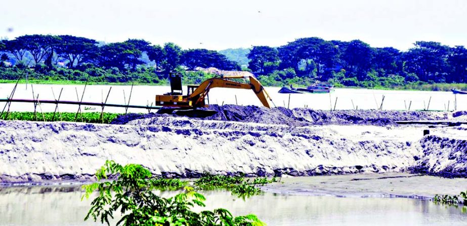 Ignoring warnings from various bodies the unscrupulous traders continuing to collect sand at Birulia area from Turag River. This photo was taken on Monday.