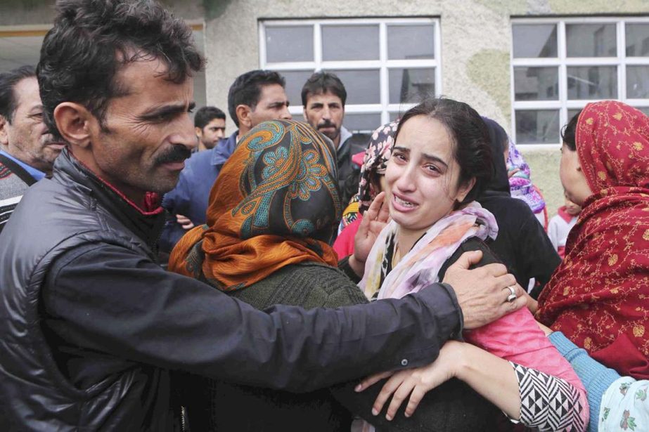 A Kashmiri man tries to comfort a flood victim as she wails after being airlifted by the army from her flooded neighborhood to the Indian Air Force base in Srinagar, India