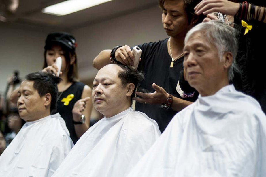 Hong Kong pro-democracy activist Benny Tai Â© gets his head shaved with others in a symbolic act of protest against Beijng's increased political control over the city, at St. Bonaventure church in Hong Kong .