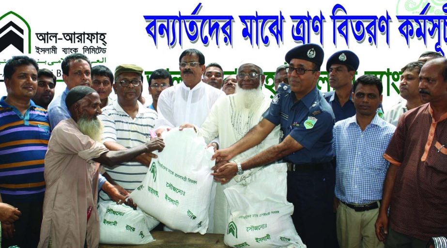 Dhunat MP Md Habibur Rahman, distributing relief goods among the flood affected people at Dhunat Primary School premises in Bogra recently on behalf of Al-Arafah Islami Bank Limited. Bogra Police Super Md Mozammel Haque and Deputy Managing Director Md Gol