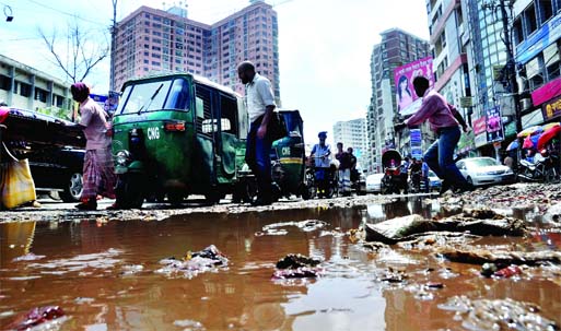 The city's busy Malibagh road is in appalling condition where stagnant rain waters created potholes and cracks causing sufferings to commuters and locals. This photo was taken on Tuesday.
