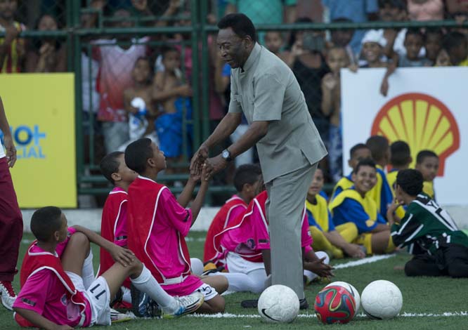 Brazilian soccer great Pele greets children during the inauguration of a soccer pitch to be powered by player's footsteps at the Morro da Mineira favela in Rio de Janeiro, Brazil on Wednesday.