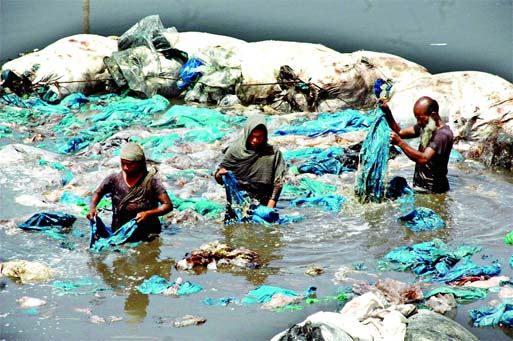 Used polythene being washed in polluted waters of a canal at Kamrangirchar before sending those for recycling to city factories. This photo was taken on Thursday.