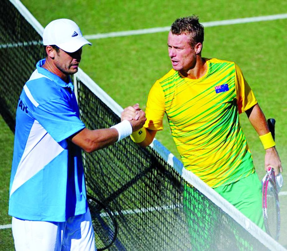 Lleyton Hewitt (right) shakes hands with Farrukh Dustov after his straight sets win in the Davis Cup World Group play-off tie in Perth on Friday.