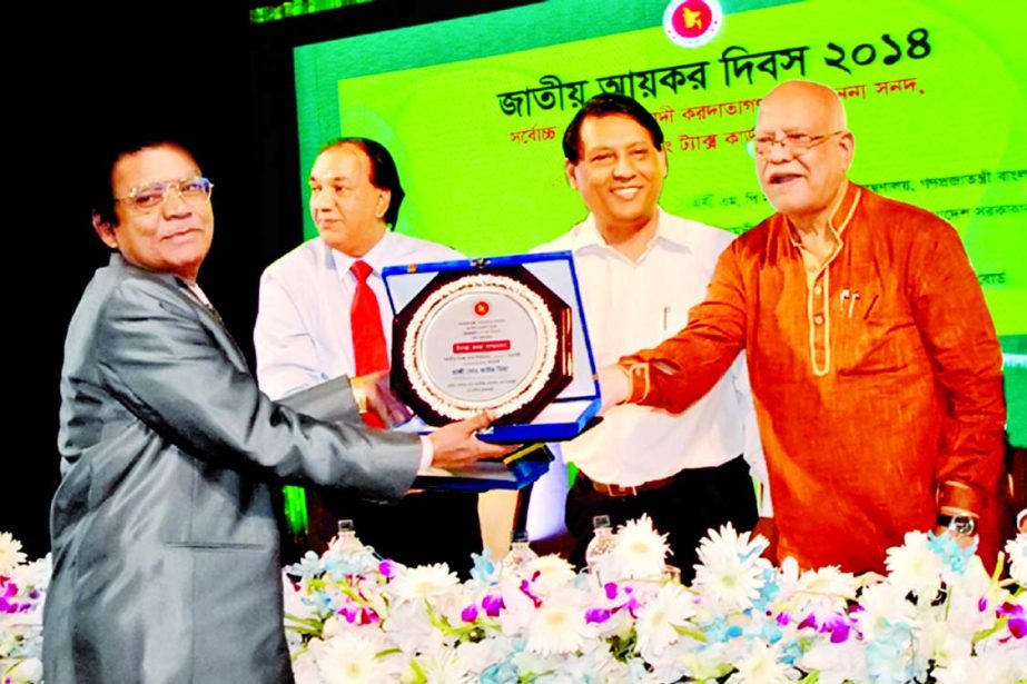 Finance Minister AMA Muhith, presenting individual top taxpayer award for the year 2013-14 to Haji Muhammad Kaous Miah at a city hotel organised by the National Board of Revenue recently.