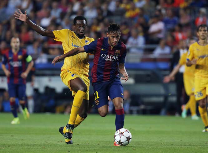 Barcelona's Neymar (right) goes to score as APOEL's De Oliveira stops him during the Champions League Group F soccer match between Barcelona and Apoel at the Camp Nou stadium in Barcelona Spain on Wednesday.