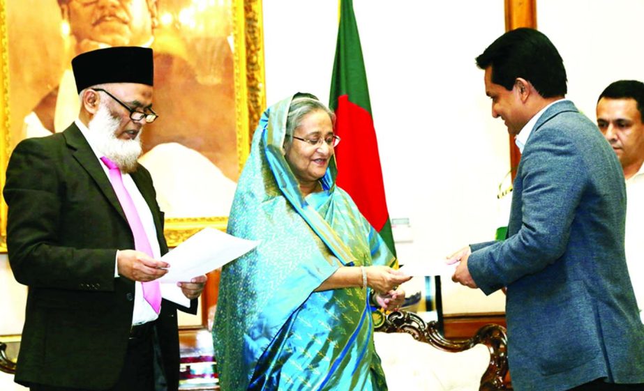 Prime Minister Sheikh Hasina receiving a cheque of Tk 10 million for her Relief Fund from AK Azad, Chairman of Shahjalal Islami Bank Limited at Ganobhaban on Thursday to rehabilitate the flood victims.
