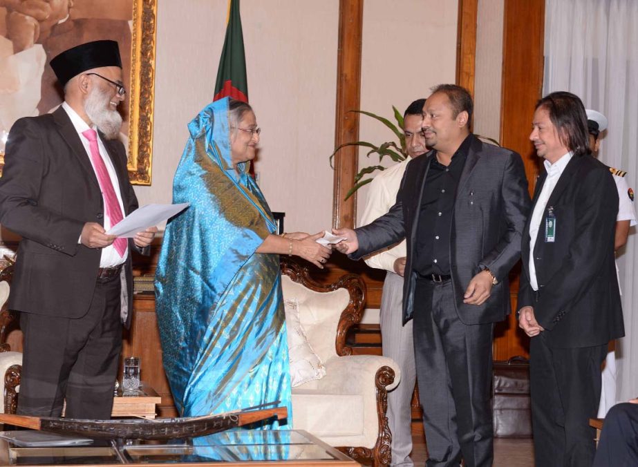 Prime Minister Sheikh Hasina receiving a cheque of Tk2.00 crore from Rick Haque Sikder, Director of National Bank Limited, for flood victims at Ganobhaban on Thursday. Ron Haque Sikder, Director of the bank was present.