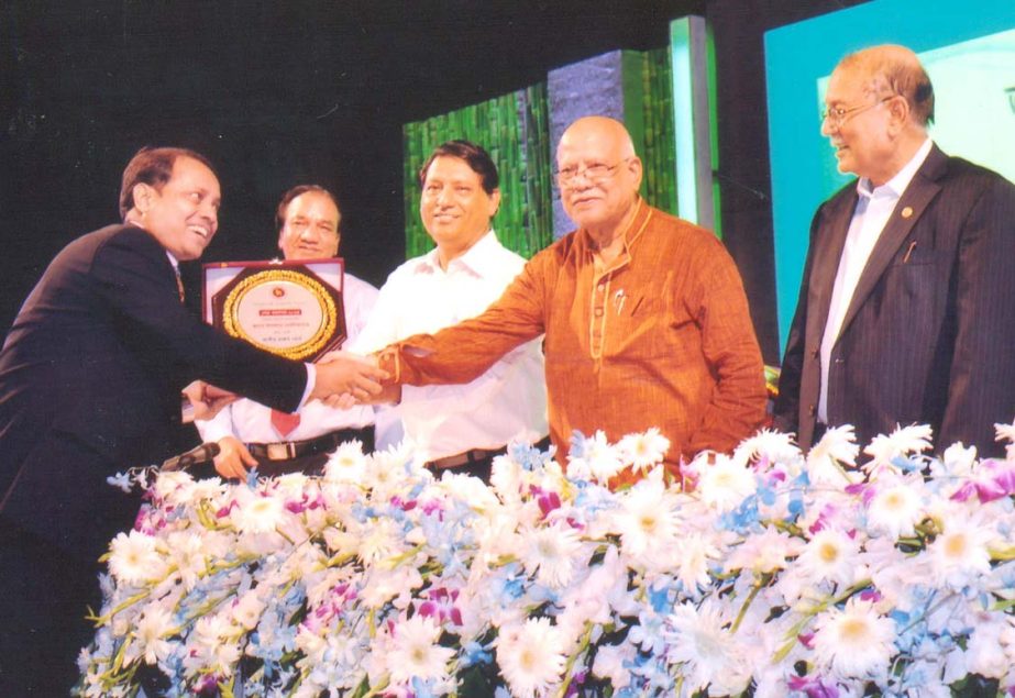 Finance Minister AMA Muhith, presenting individual top taxpayer award to Md Aslam Serniabad, Proprietor of Car Selection, for the year 2013-14 at a city hotel recently.