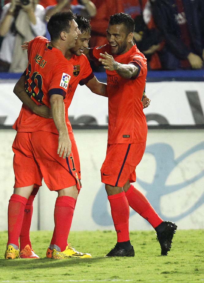 Barcelona's Neymar from Brazil (center) is congratulated by teammate Lionel Messi from Argentina (left) and Dani Alves from Brazil (right) after Neymar scored a goal against Levante during a Spanish La Liga soccer match at the Ciutat de Valencia stadium