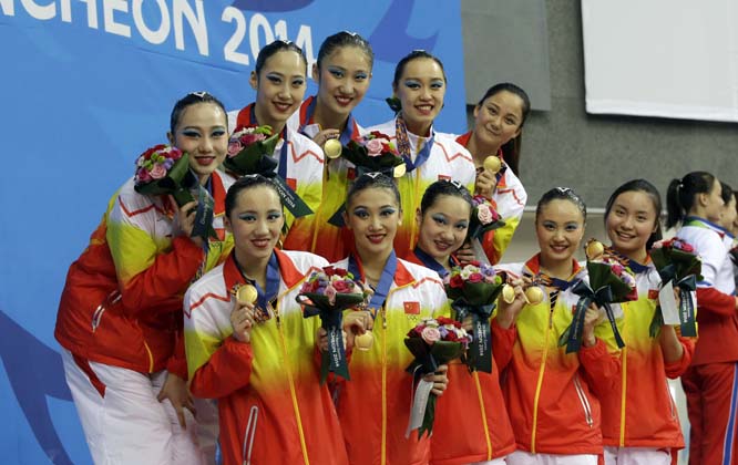 Chinese synchronized swimming team members smile with their gold medals after performing their synchronized swimming team free routine at the 17th Asian Games in Incheon, South Korea on Monday.