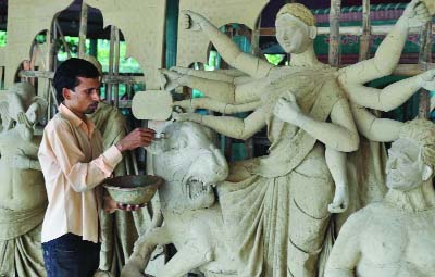 DUPCHANCHIA(Bogra): Idols makers passing busy time at Dupchanchia Upazila. This picture was taken on Monday.