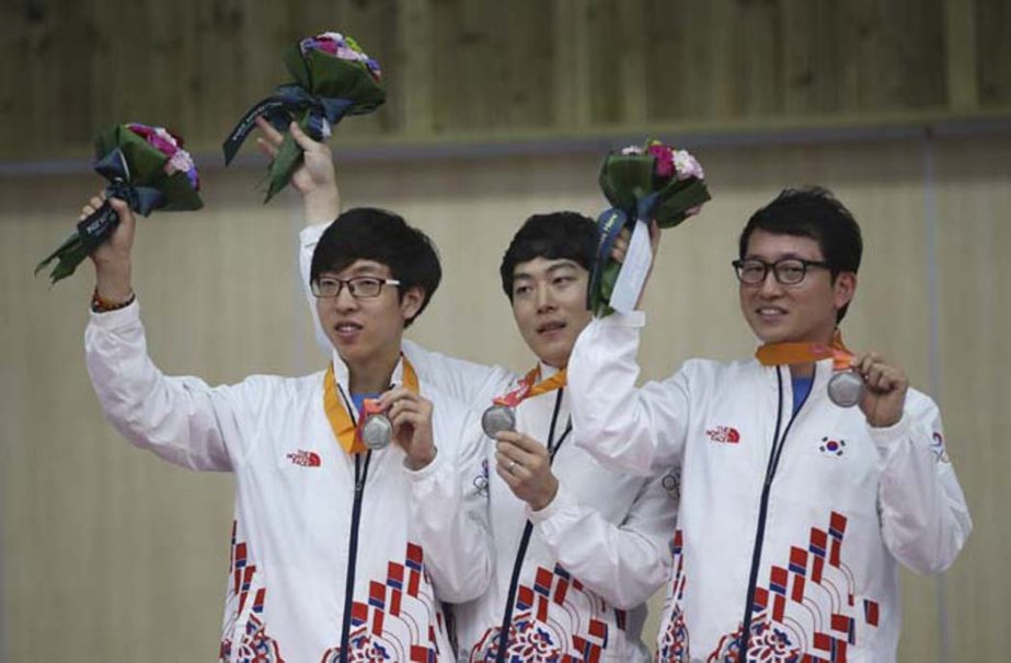 South Korea's Silver Medalists Kim Hyeon-jun (left) Kim Sang-do (center) Han Jin-seop (right) celebrate during the victory ceremony for the Men's 10m Air Rifle group competition at the 17th Asian Games in Incheon, South Korea on Tuesday.