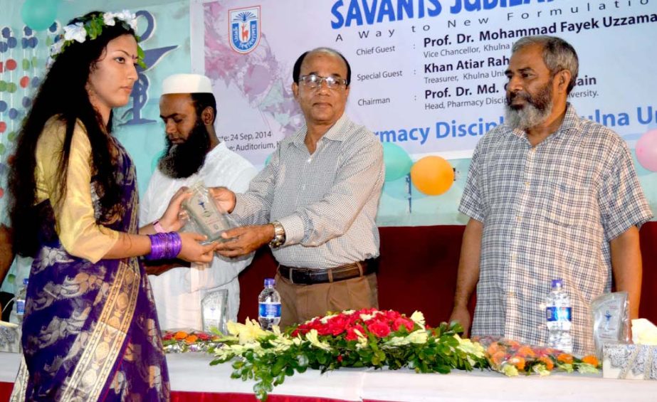 Khulna University Treasurer Khan Atiar Rahman is seen distributing crests among the newly enrolled students at 13th Batch of the university's Pharmacy Department on Wednesday.