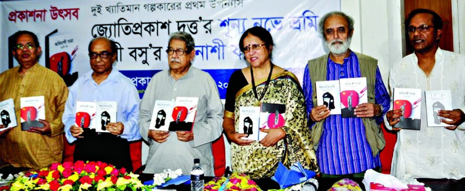Noted educationist and Professor Emeritus of Dhaka University Dr Anisuzzaman along with other distinguished guests hold the copies of two books titled 'Shunya Nove Vramy' and 'Abinashi Jatra' written by Jyotiprokaksh Dutta and Purabi Basu respectively