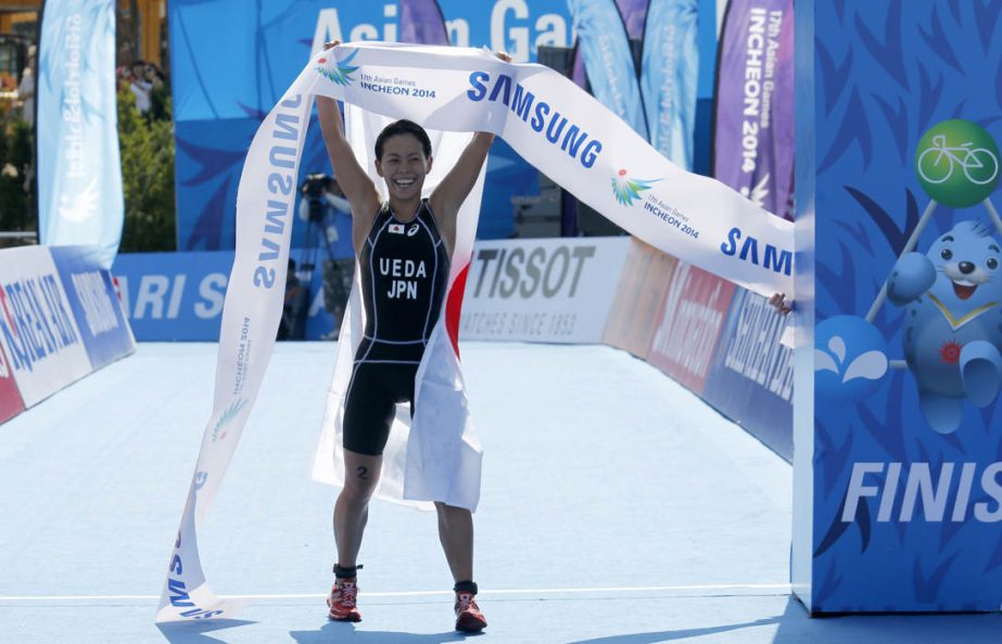 Gold medallist Ai Ueda of Japan holds up the finish line ribbon during the women's triathlon competition of the 17th Asian Games at the Songdo Central Park in Incheon on Thursday.
