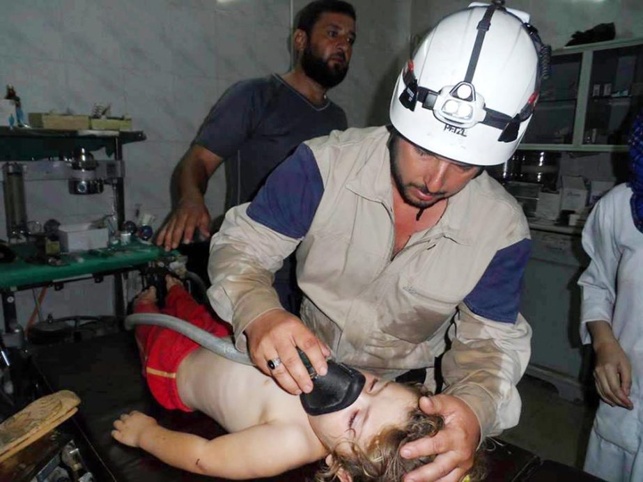 Civil Defense Idlib, a group of volunteers in northern Syria which has been authenticated based on its contents and other AP reporting, show a Syrian civil defense worker with his white helmet, treats a girl, in Idlib province, northern Syria.