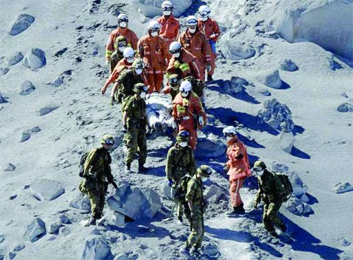 Japan Self-Defense Force (JSDF) soldiers and firefighters carry an injured person near a crater of Mt. Ontake, which straddles Nagano and Gifu prefectures on September 28. Internet photo