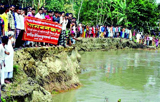Hundreds of flood affected people of 10 villages under Saghata UZ of Gaibandha formed human chain on the bank of the Jamuna River on Sunday seeking immediate protection from erosion. Banglar Chokh